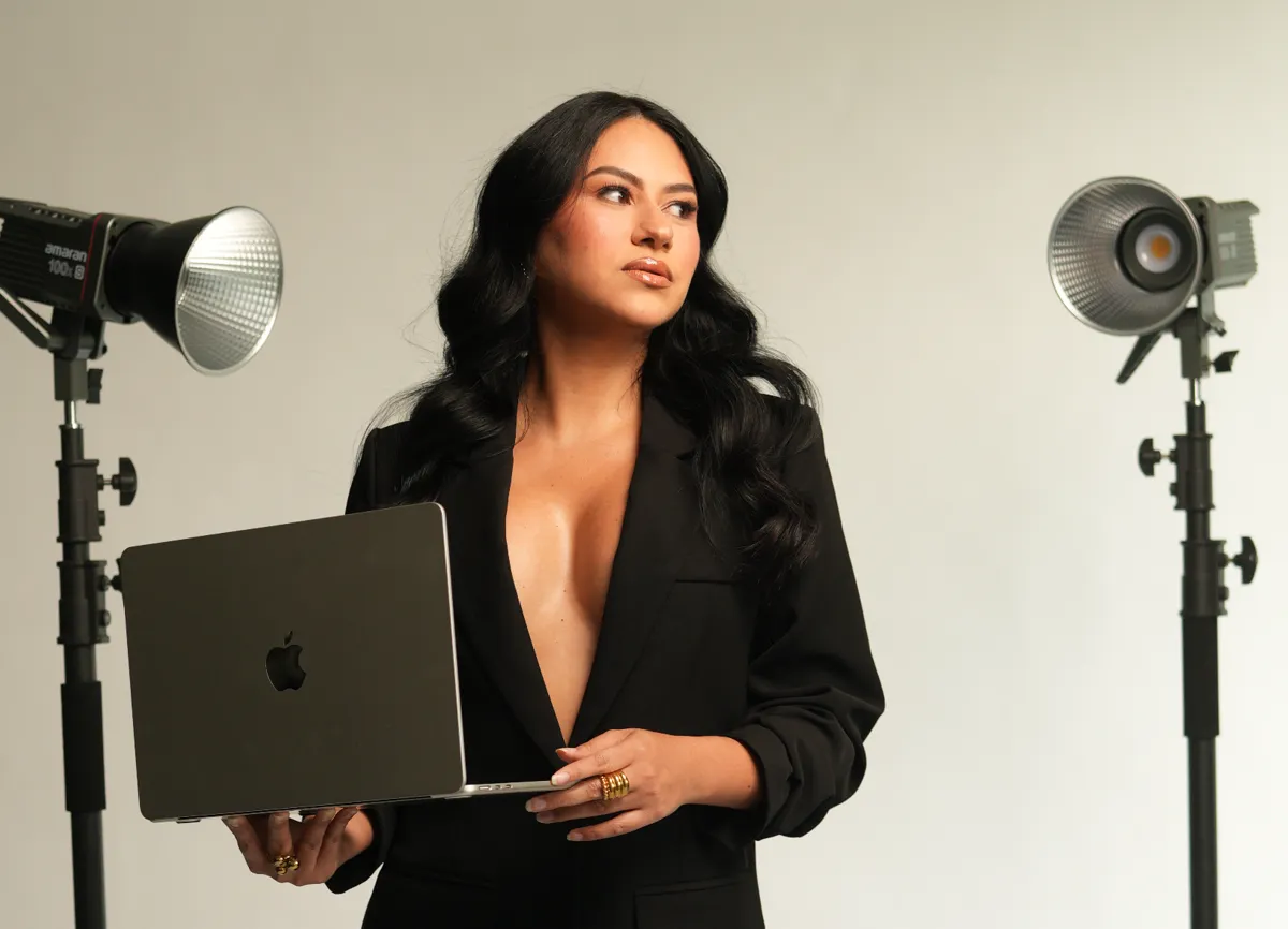Jackie Sánchez holding a laptop in the studio